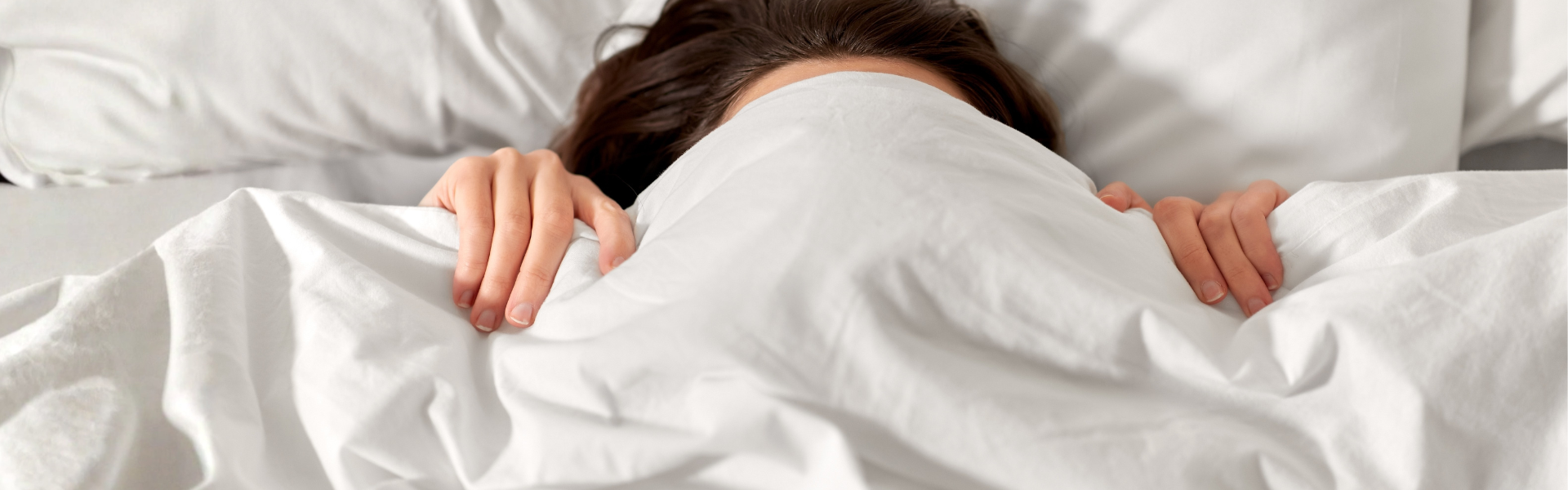 Woman lying snuggled up in bed.