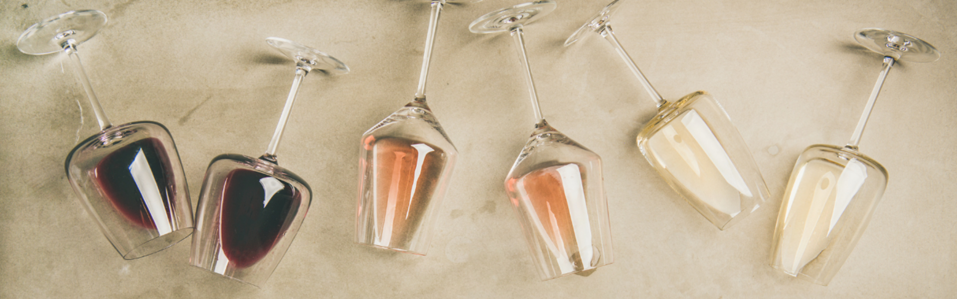 Various filled wine glasses photographed lying down from above.