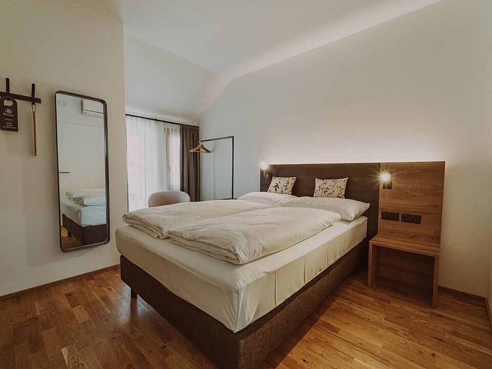 Bed in an Eco double room at the Burghotel Schlaining.