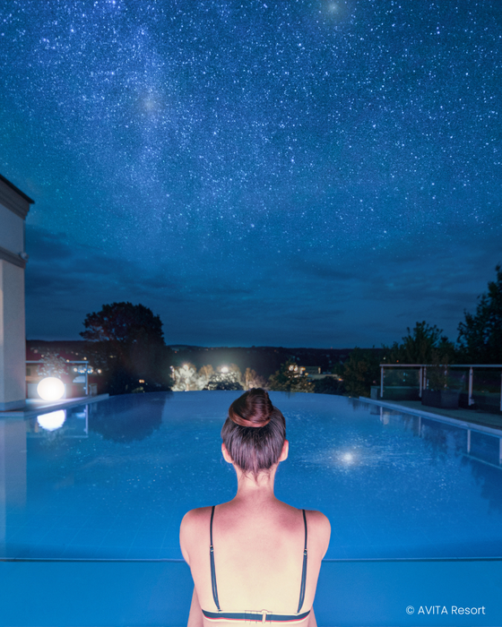Woman in the infinity pool at night.