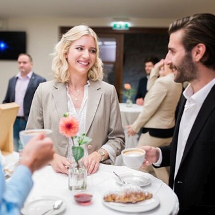 Seminar guests chat at the bar table in the seminar hotel Schlaining.