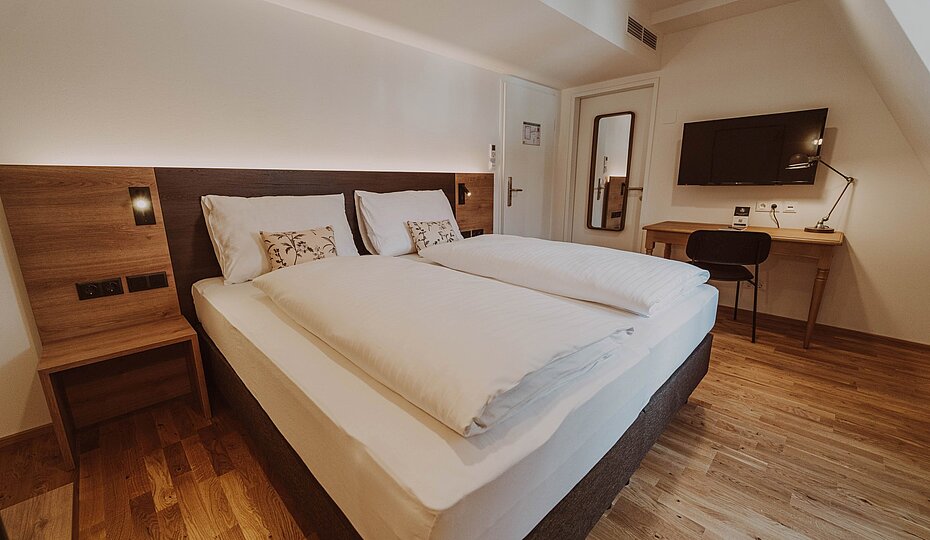 Bed in a standard double room at Burghotel Schlaining.